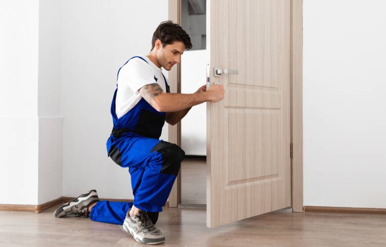 Een werkman die een deur plaatst.