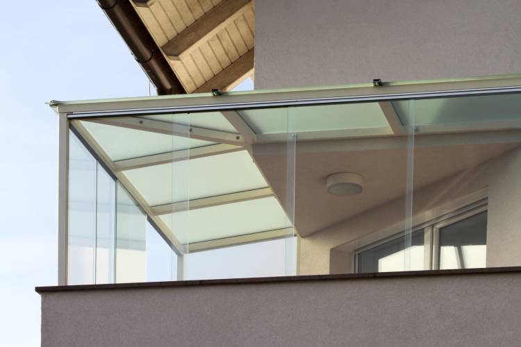 Een terras met een windscherm gemaakt van gehard glas.